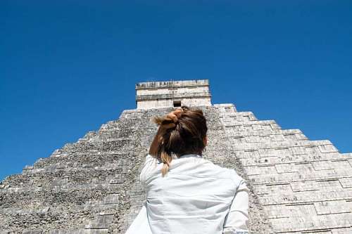 mexico Mujer de espaldas mirando la gran piramide Maya de Chichen Itza 