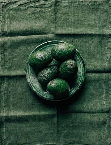 mexico plano de aguacates sobre un plato con un mantel verde de fondo