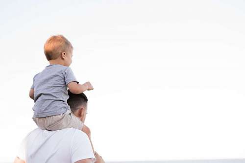 copyspace Padre con su hijo en los hombros mirando el horizonte 