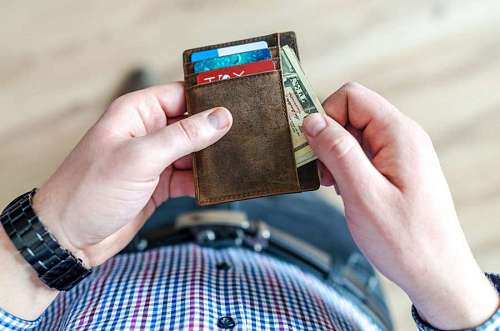 billete Hombre sacando dinero de su billetera para comprar en negocio