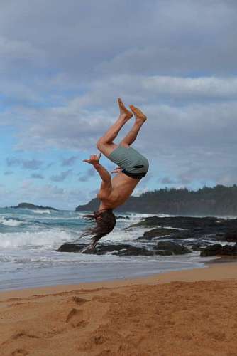 Hombre saltando para atras en la playa