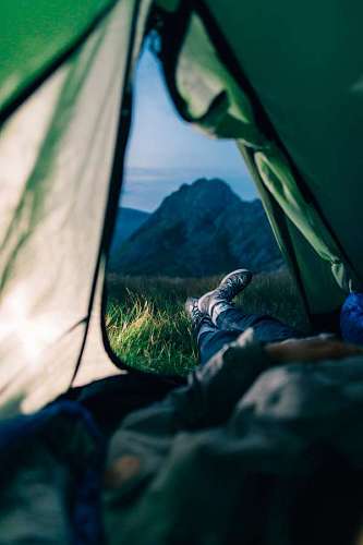 mochila Hombre en una carpa mirando el paisaje de montaña