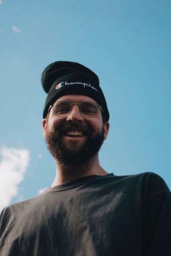 hipster Hombre joven con barba y gorro sonriendo mientras mira a la camara