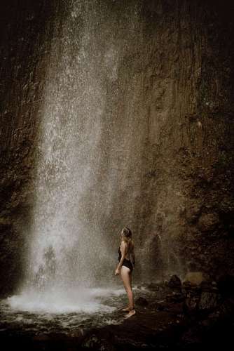 paisaje de invierno mujer parada frente a hermosa cascada