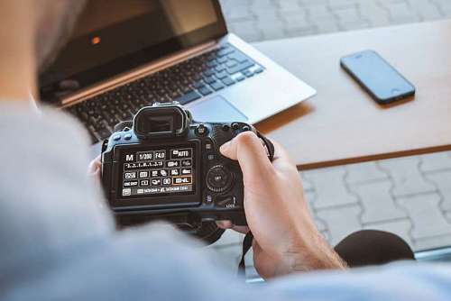 pc primer plano de un hombre configurando su cámara de fotos
