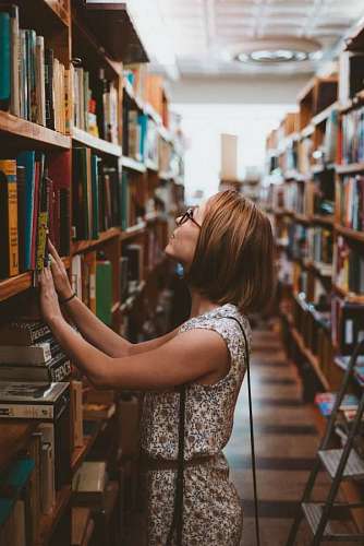 mujer mirando libros en una biblioteca