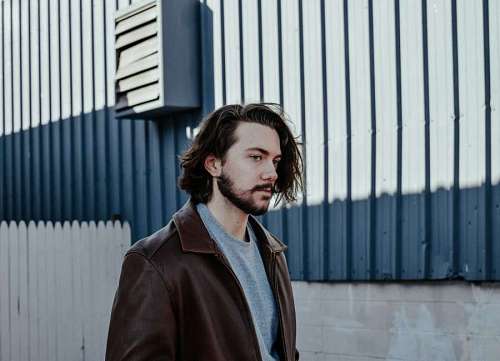 hipster Hombre joven elegante caminando en la ciudad