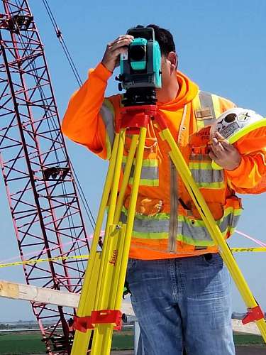 topografia obrero fotografiando una construcción