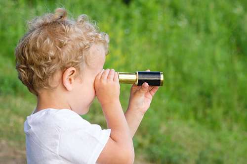 telescopio Niño pequeño mirando con telescopio en el jardin