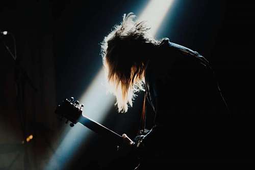 Hombre tocando la guitarra en un concierto de rock