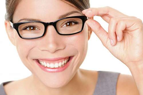 blanco y negro Mujer joven sonriente con gafas mirando a la camara