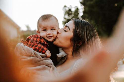 Madre besando a su hijo en la mejilla