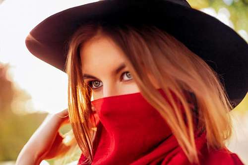 solitario Mujer joven con pañuelo rojo en la cara y mirada sensual