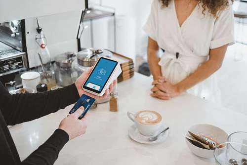 cliente primer plano de una mujer realizando un pago con tarjeta de crédito 