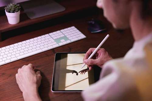 Diseñador retocando una imagen digital con tableta desde su casa