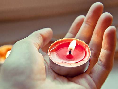 susto Mano sosteniendo una vela encendida