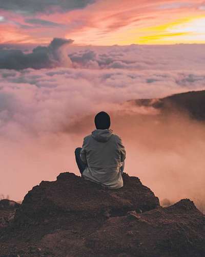 parte superior Hombre meditando en la cima de una montaña 