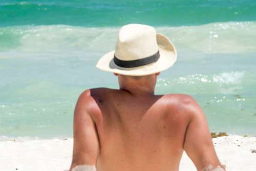 recurso Hombre de espaldas tomando sol en una playa del caribe