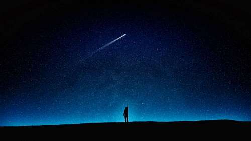 silueta de un niño miran un cometa en el cielo estrellado