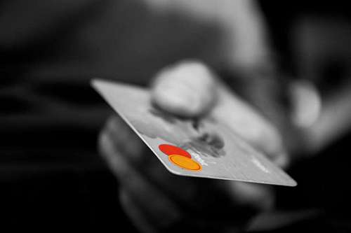 cliente primer plano en blanco y negro de una mano sosteniendo una tarjeta de crédito