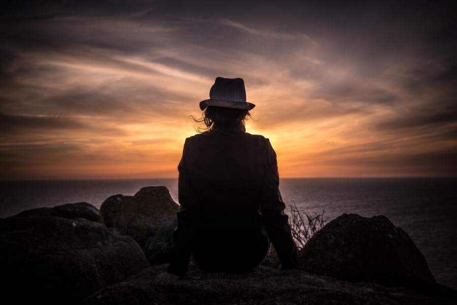 una persona, gente, mujer, atardecer, ocaso, puesta de sol, espaldas, silueta, mirando el horizonte, gorro, 