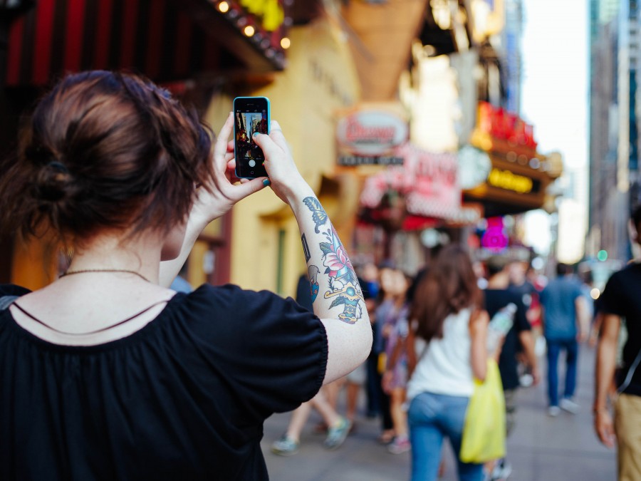 una persona, gente, mujer, tatuaje, celular, telefono, smartphone, fotografia, ciudad, viaje, viajar, joven, 20 aos, vista de atras, urbano, calle, 