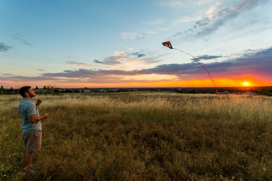 una persona, gente, hombre, joven, remontar, cometa, juego, diversion, campo, aire libre, exterior, atardecer
